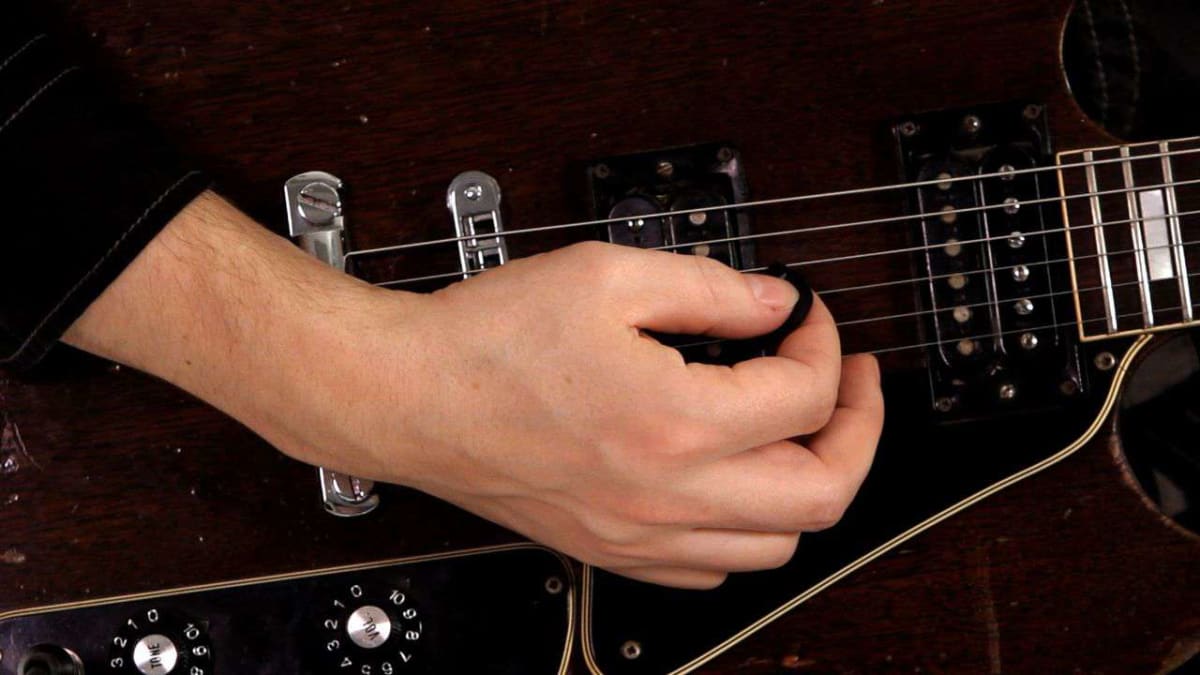Holding a guitar pick new arrivals